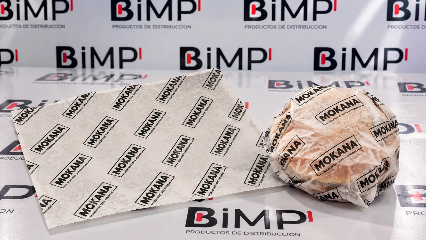 Papel antigrasa personalizado con logo envolviendo un bocadillo